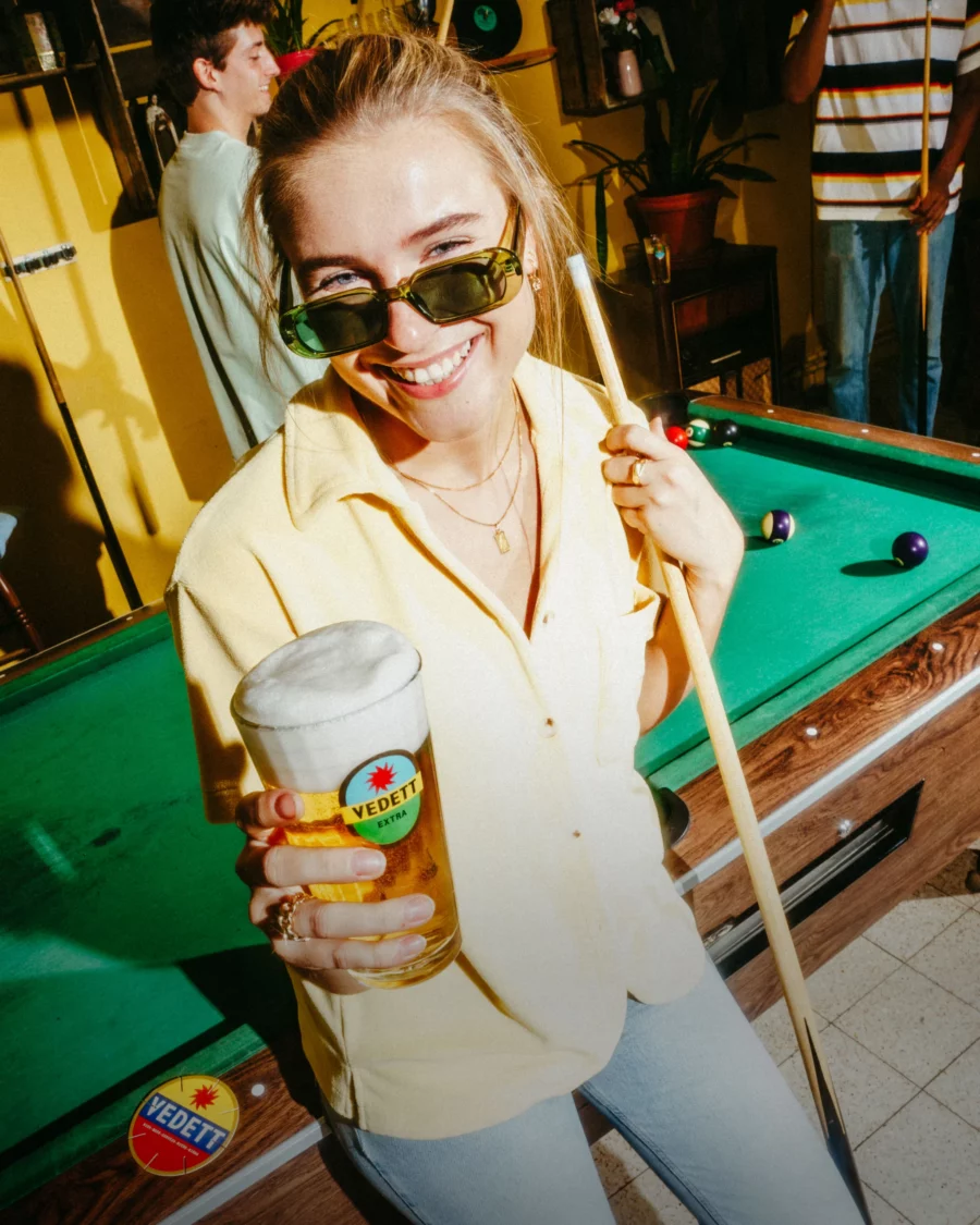 ragazza tiene in mano un bicchiere di birra vedett